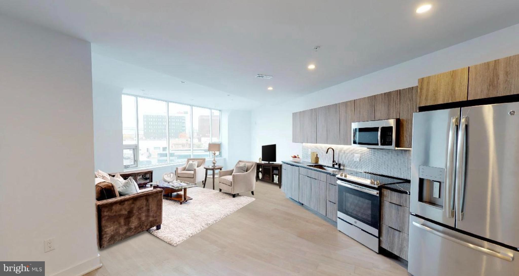 1 Brown Street, Unit STUDIO Philadelphia, PA 19123 - Photo 7 of 14 a kitchen with stainless steel appliances granite countertop a refrigerator a stove a sink dishwasher a oven with white cabinets and wooden floor