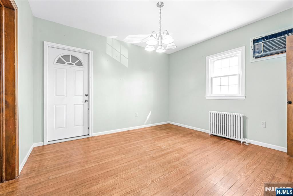 78 Columbia Street Wood-Ridge, NJ 07075 - Photo 11 of 25 an empty room with wooden floor chandelier and windows