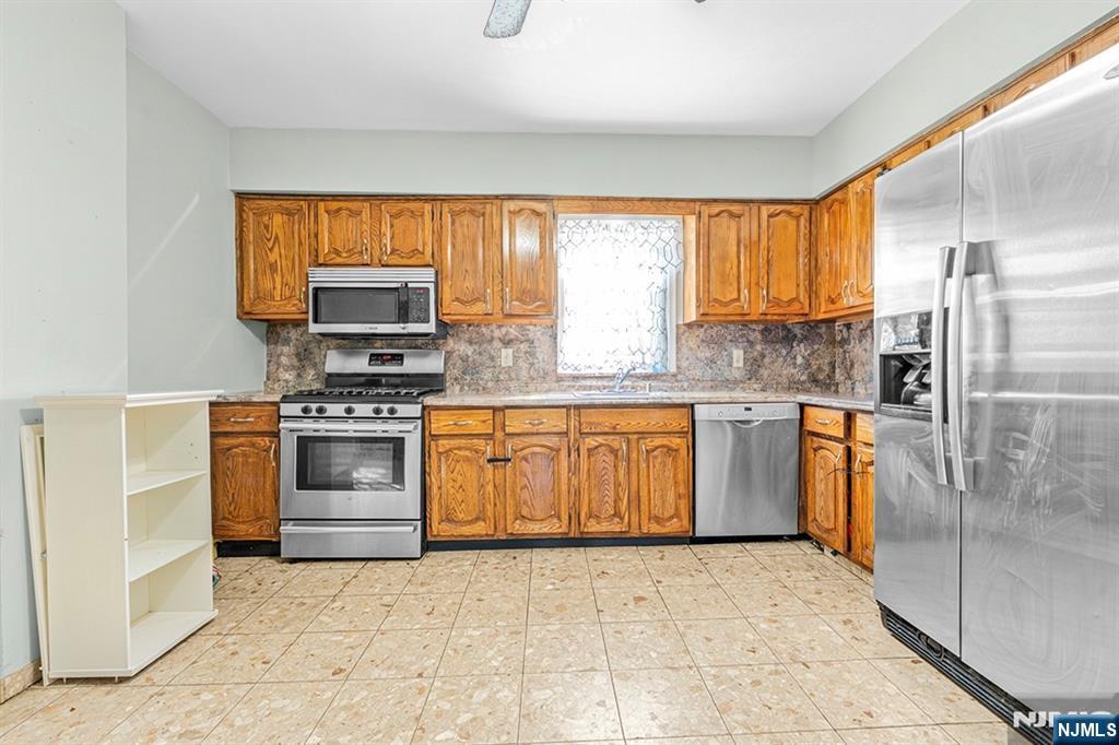 78 Columbia Street Wood-Ridge, NJ 07075 - Photo 8 of 25 a kitchen with stainless steel appliances granite countertop a stove a sink and a refrigerator
