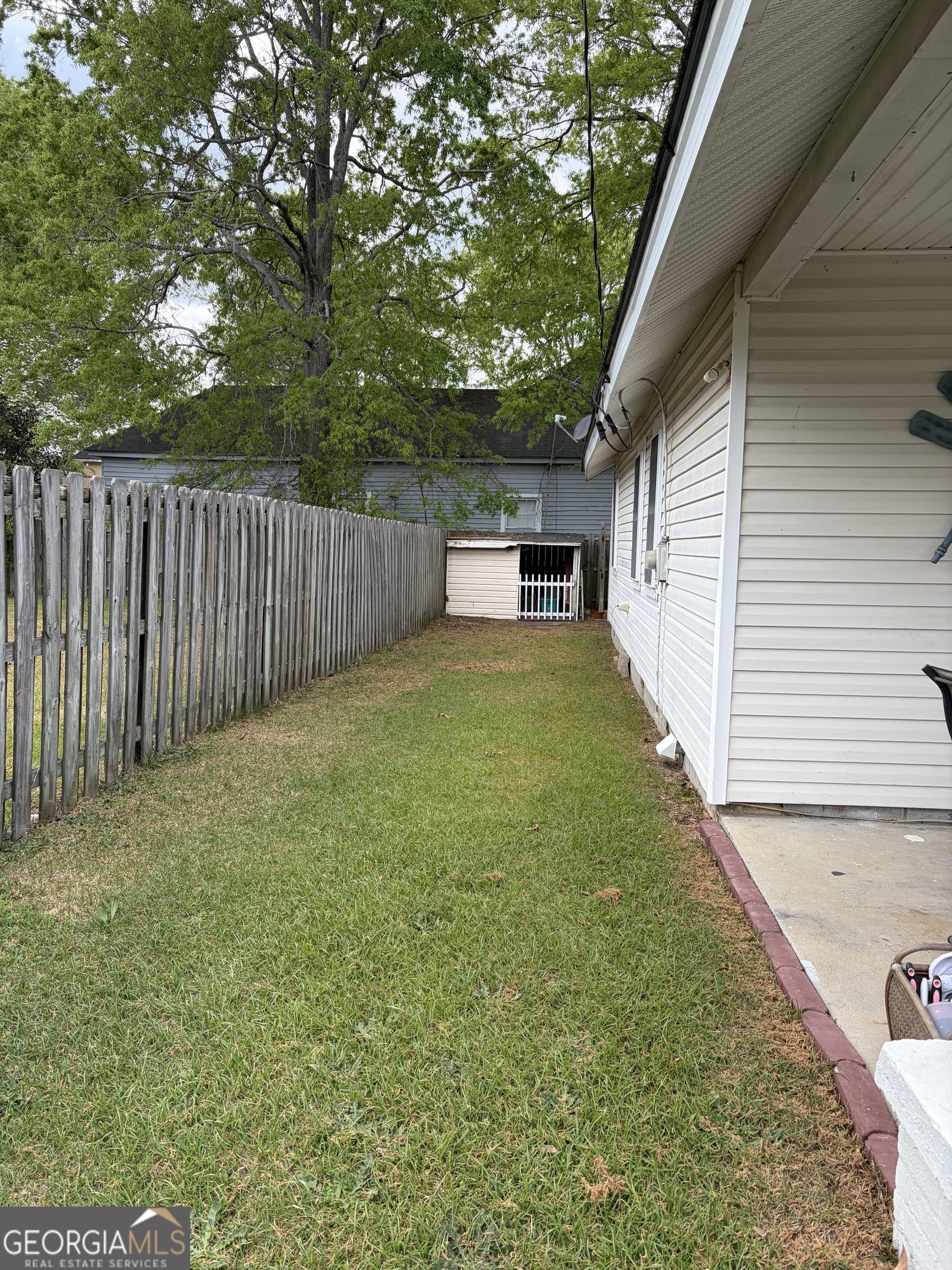 223 Holt Street Thomson, GA 30824 - Photo 24 of 24 a view of a backyard with large trees and wooden fence