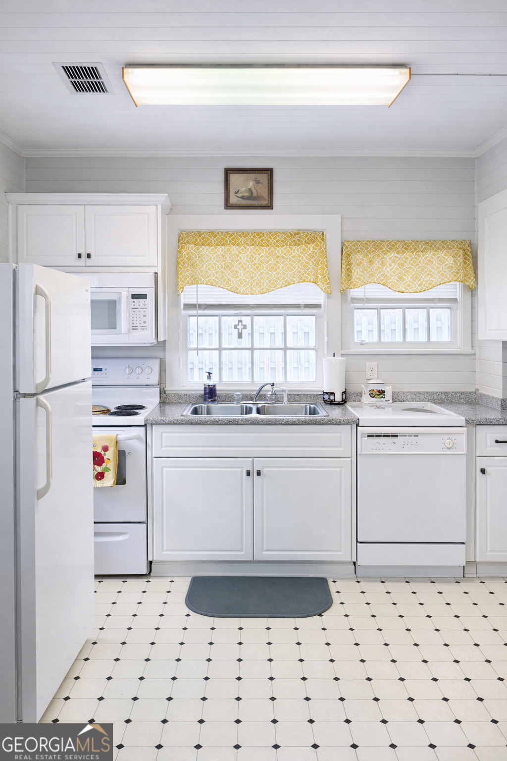 223 Holt Street Thomson, GA 30824 - Photo 6 of 24 a kitchen with granite countertop white cabinets and white appliances