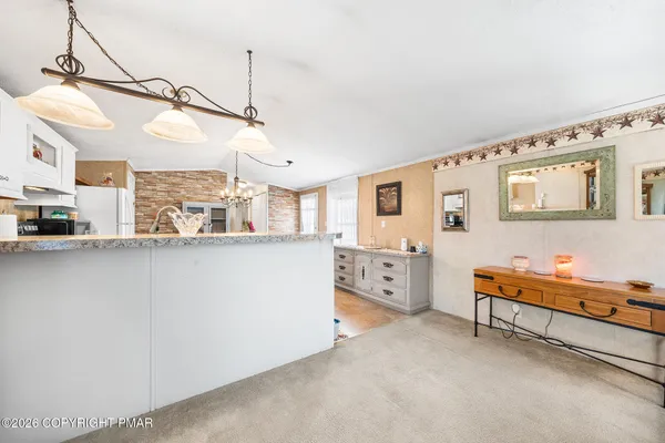 a kitchen with stainless steel appliances kitchen island granite countertop a refrigerator and microwave