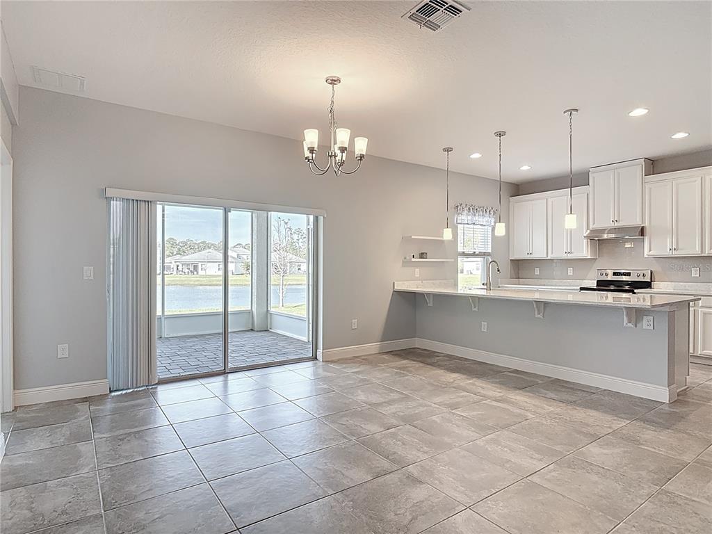 5644 Estero Loop Port Orange, FL 32128 - Photo 11 of 50 a large kitchen with granite countertop a stove a sink and a refrigerator