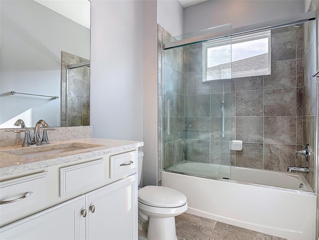 5644 Estero Loop Port Orange, FL 32128 - Photo 24 of 50 a bathroom with a granite countertop sink a toilet and bathtub