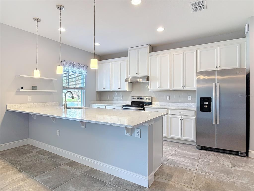 5644 Estero Loop Port Orange, FL 32128 - Photo 3 of 50 a kitchen with kitchen island a sink stainless steel appliances and cabinets