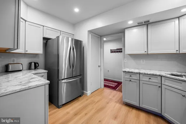 a kitchen with granite countertop a refrigerator and cabinets