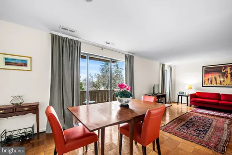 a view of a dining room with furniture a rug and wooden floor