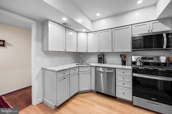 a kitchen with stainless steel appliances granite countertop a stove a sink and a microwave