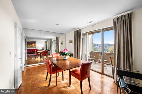 a dining room with furniture and a floor to ceiling window