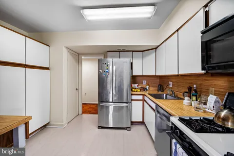 a kitchen with stainless steel appliances a refrigerator a sink a stove and cabinets