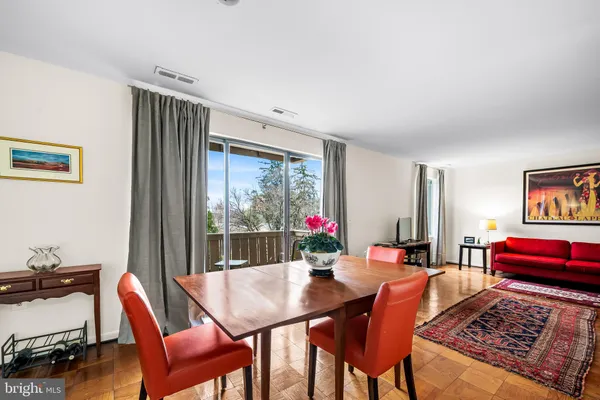 a view of a dining room with furniture a rug and wooden floor