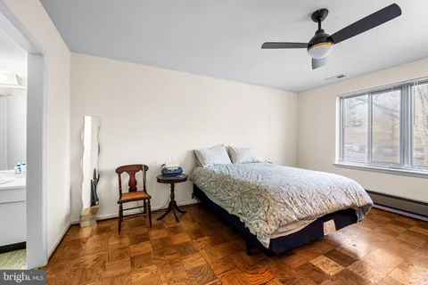 a bedroom with a bed chair and window