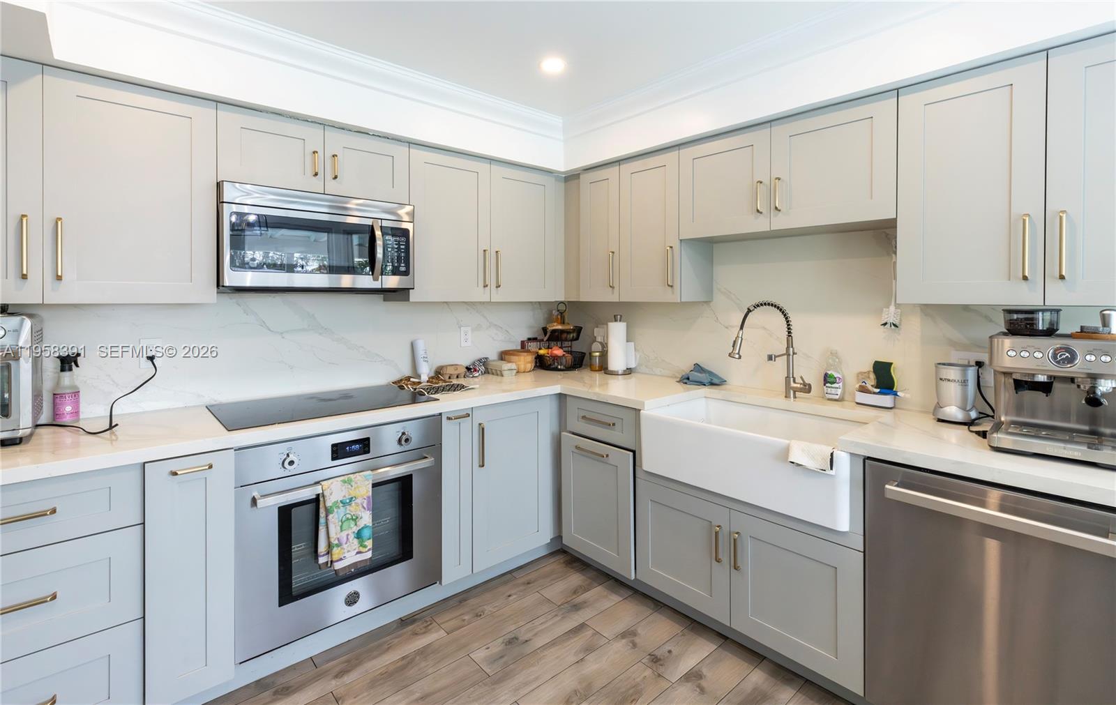 12415 Southwest 93rd Court Miami, FL 33176 - Photo 12 of 30 a kitchen with stainless steel appliances granite countertop white cabinets a sink a stove a microwave and wooden cabinets