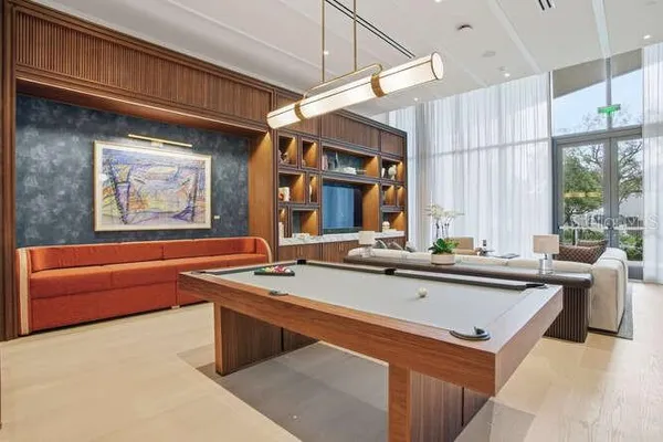 a living room with furniture a flat screen tv a rug and a mirror