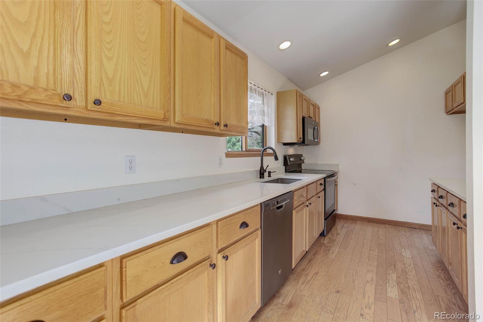 45 Catamount Ridge Road Bailey, CO 80421 - Photo 18 of 39 a kitchen with granite countertop white cabinets and white appliances