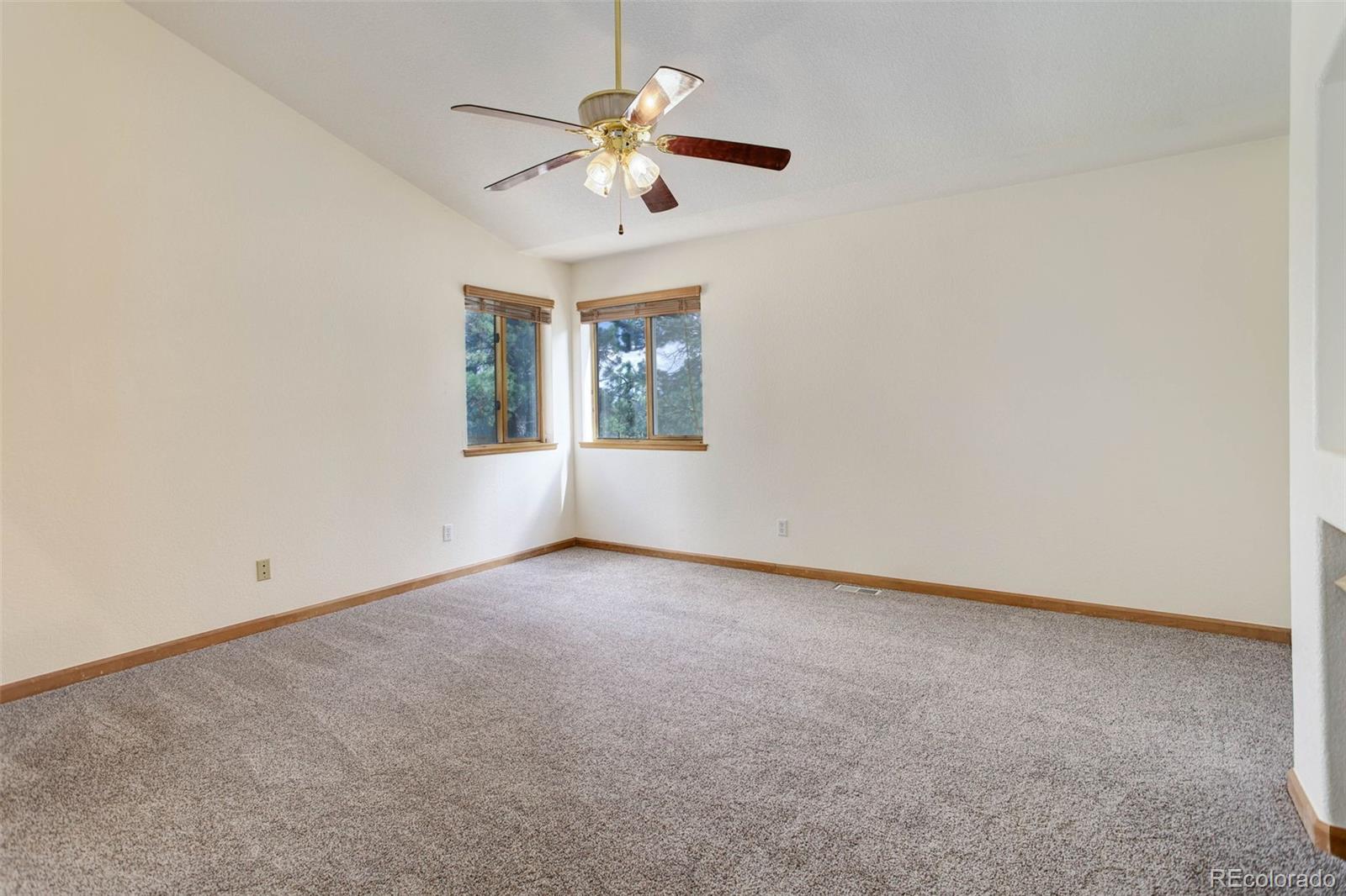 45 Catamount Ridge Road Bailey, CO 80421 - Photo 23 of 39 an empty room with a chandelier fan and windows