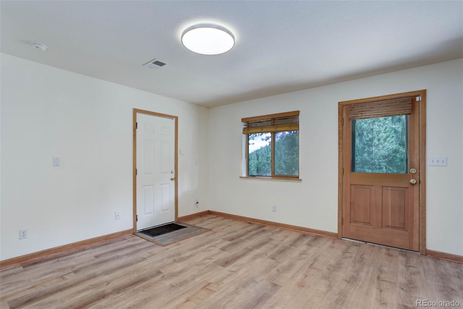 45 Catamount Ridge Road Bailey, CO 80421 - Photo 28 of 39 an empty room with wooden floor and windows