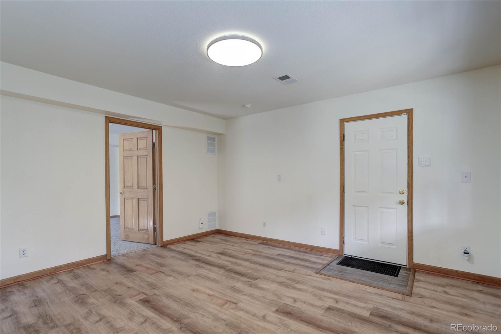 45 Catamount Ridge Road Bailey, CO 80421 - Photo 29 of 39 an empty room with wooden floor and windows