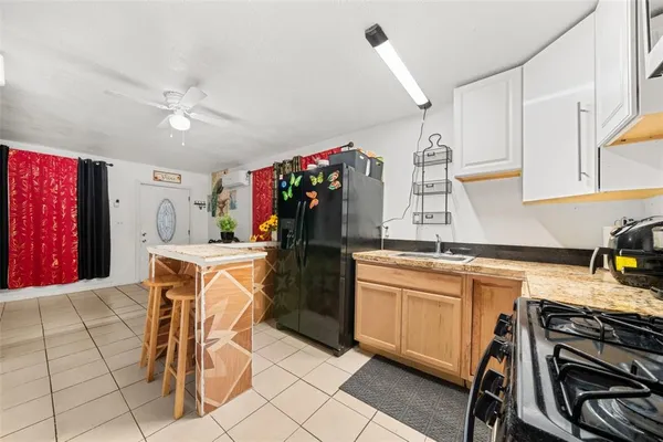 a kitchen with stainless steel appliances kitchen island granite countertop a stove top oven a sink a dining table and chairs with wooden floor