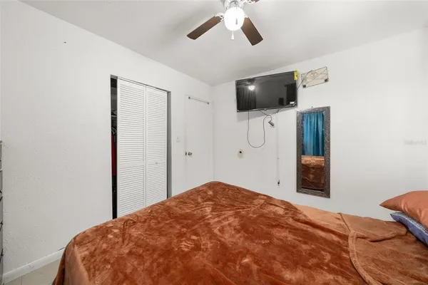 a bedroom with a bed and a flat screen tv