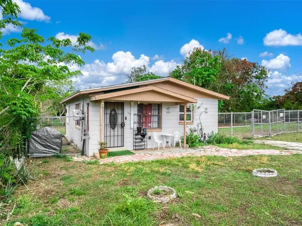a view of a house with backyard and sitting area