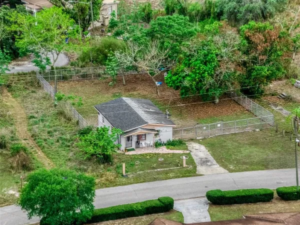 a aerial view of a house with a yard and a large tree