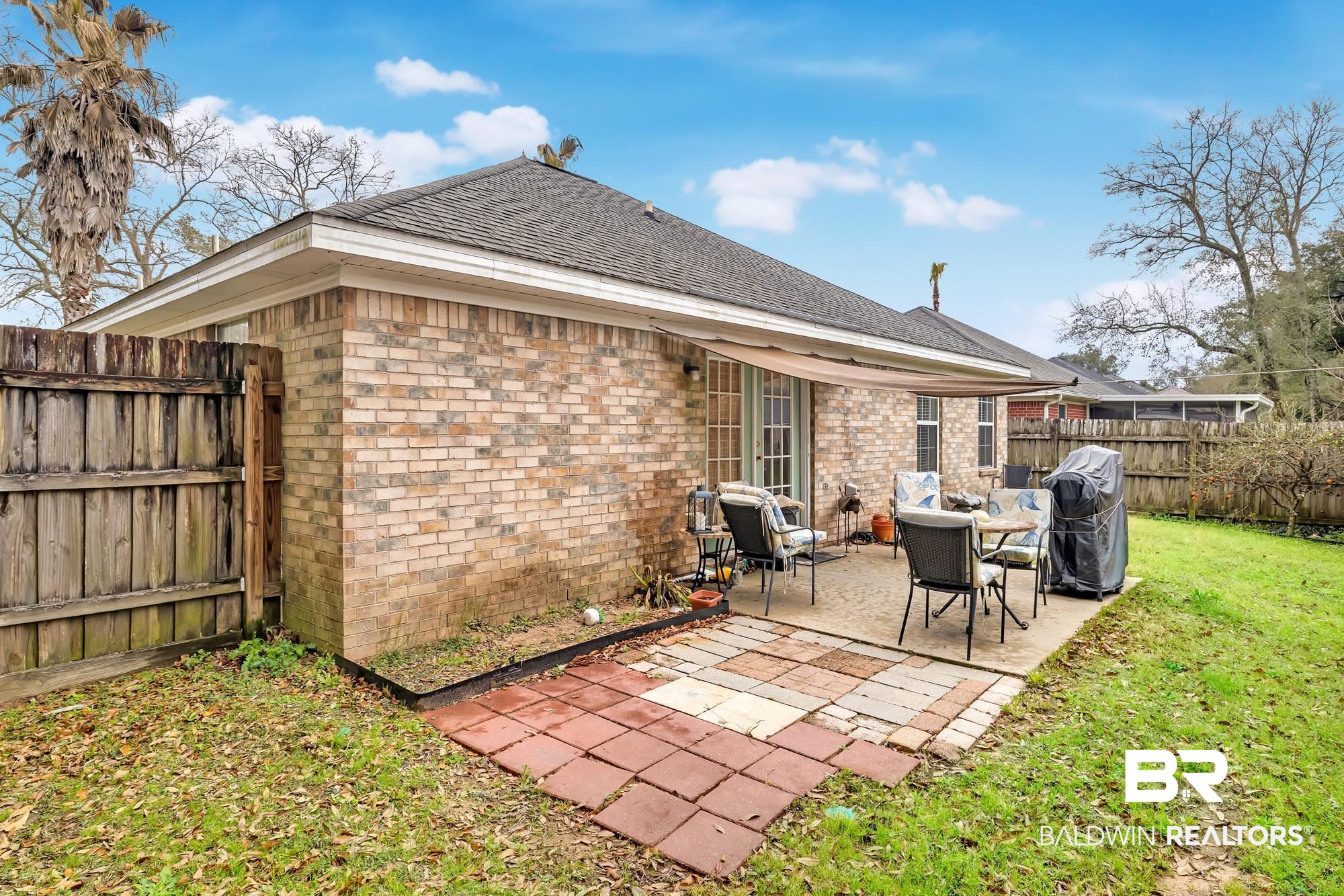 105 Cluster Oaks Court Foley, AL 36535 - Photo 8 of 26 Rear view of property with roof with shingles, brick siding, a fenced backyard, and a patio