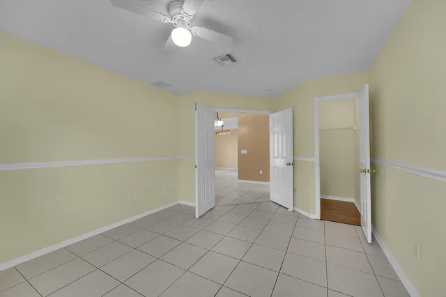 an empty room with a white cabinet and a window