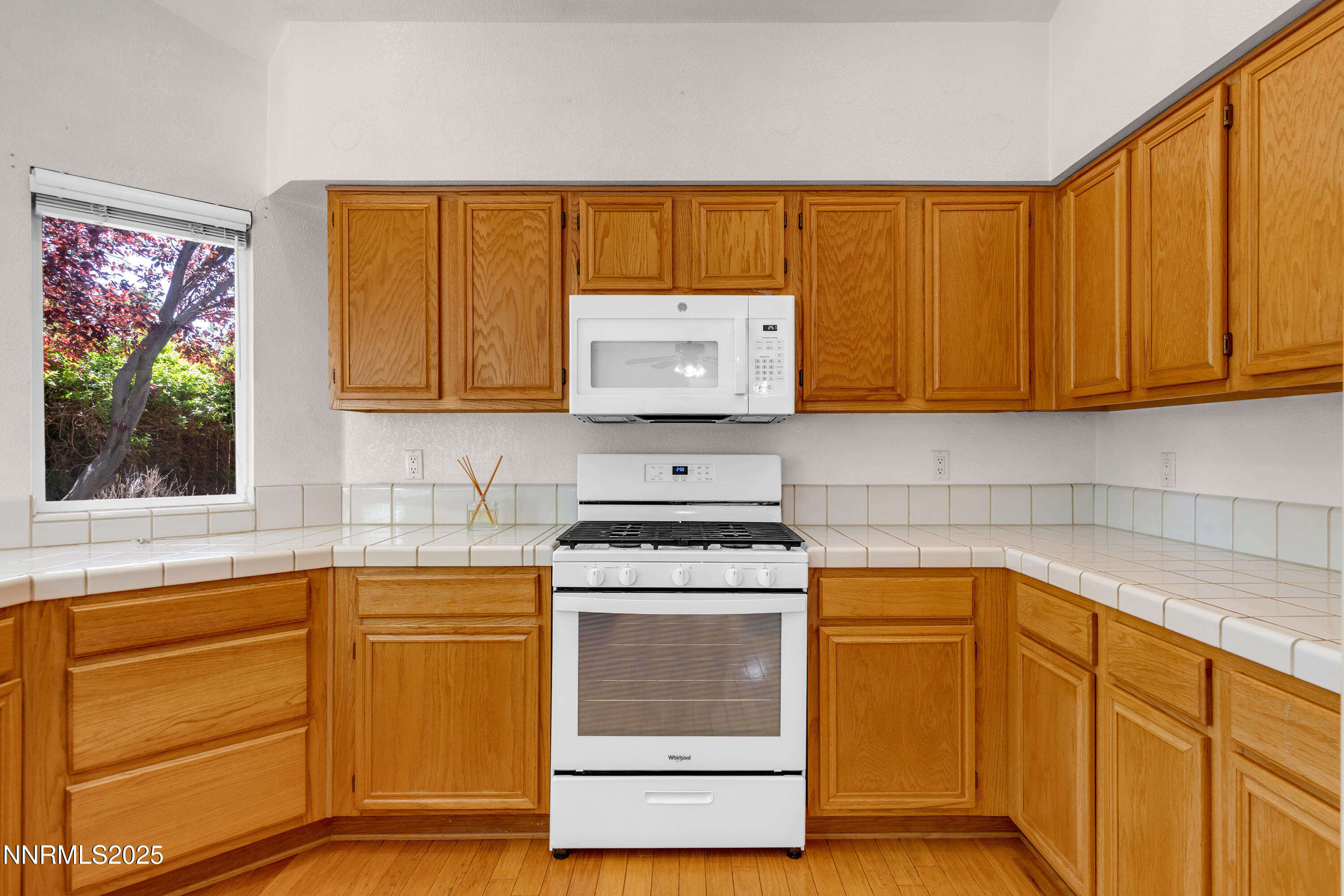 1850 Tess Way Reno, NV 89511 - Photo 11 of 50 a kitchen with granite countertop cabinets stainless steel appliances and wooden floor