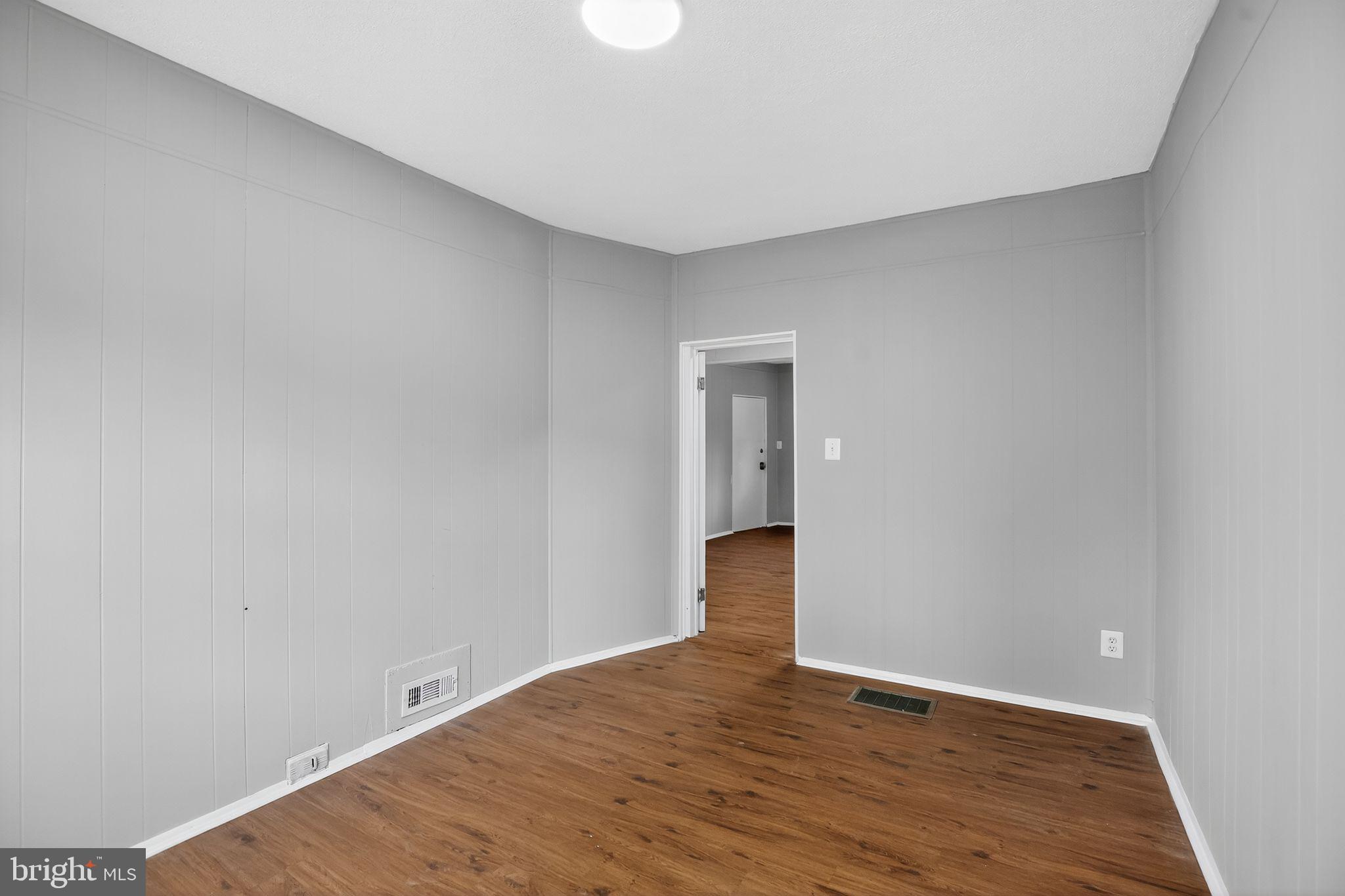 5446 Narcissus Avenue, Unit 1 Baltimore, MD 21215 - Photo 11 of 21 a view of an empty room with wooden floor and a window