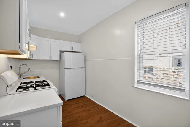 a kitchen with a stove a refrigerator and a window