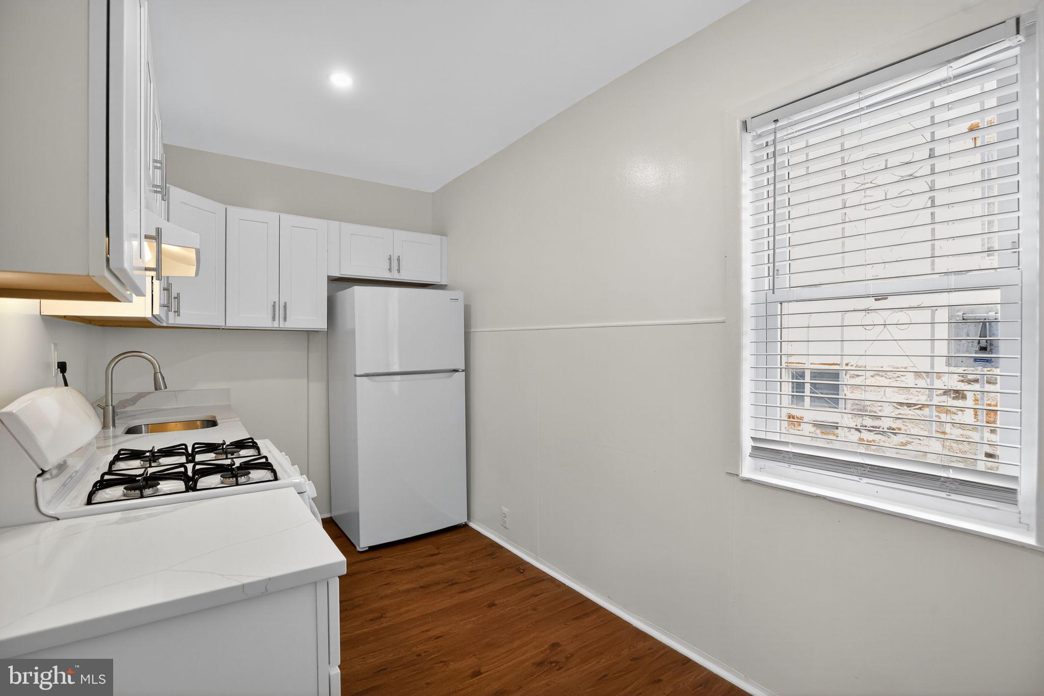 5446 Narcissus Avenue, Unit 1 Baltimore, MD 21215 - Photo 15 of 21 a kitchen with a stove a refrigerator and a window