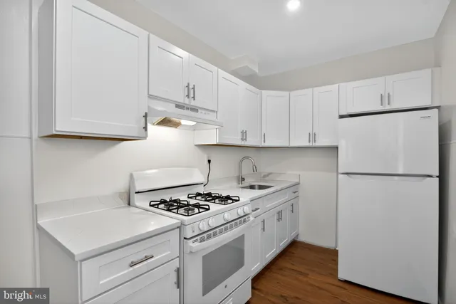 a kitchen with white cabinets and white appliances