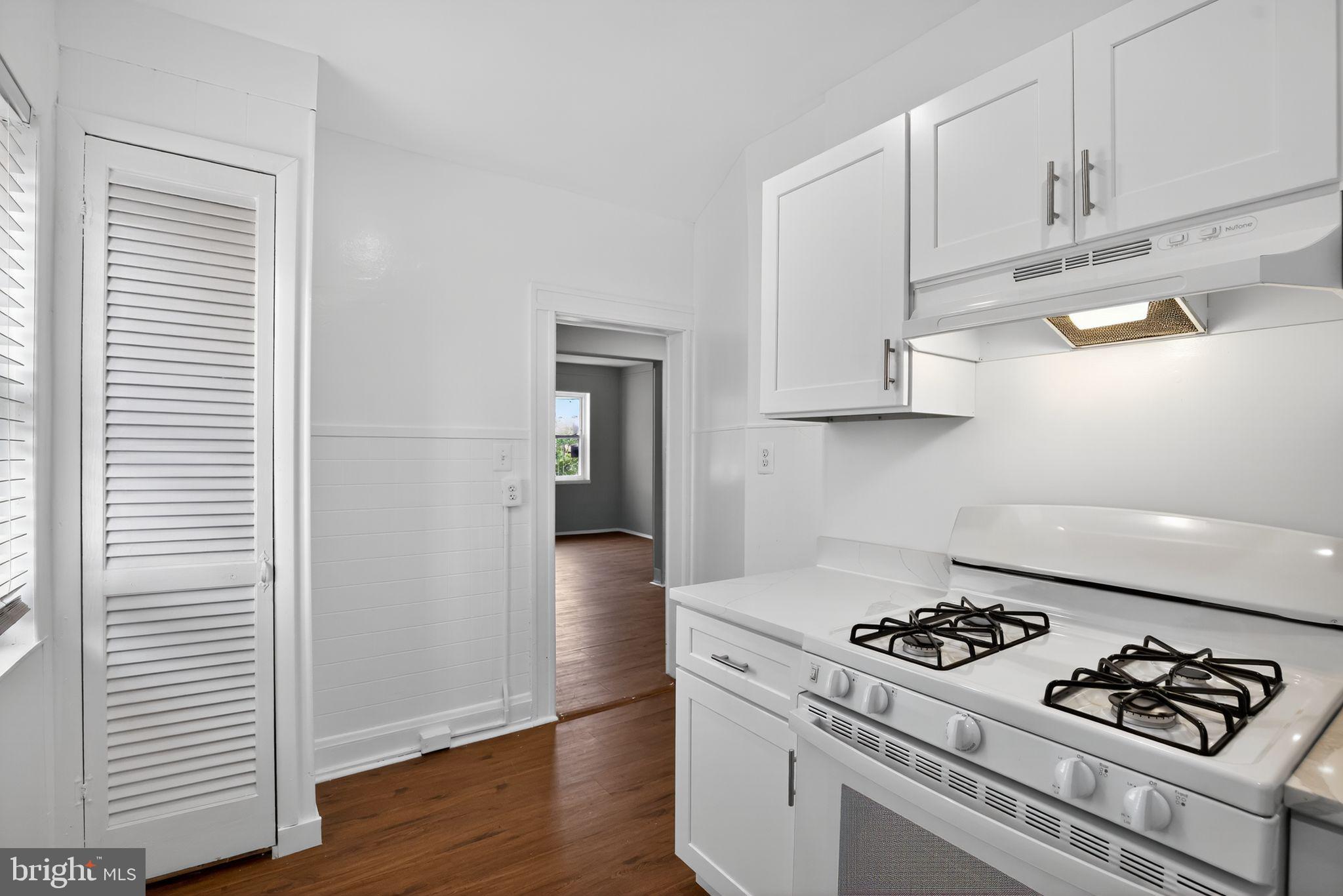 5446 Narcissus Avenue, Unit 1 Baltimore, MD 21215 - Photo 17 of 21 a kitchen with white cabinets and a stove