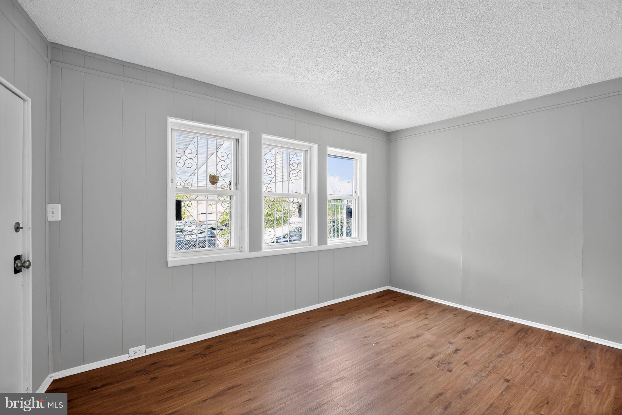 5446 Narcissus Avenue, Unit 1 Baltimore, MD 21215 - Photo 10 of 21 a view of an empty room with wooden floor and a window