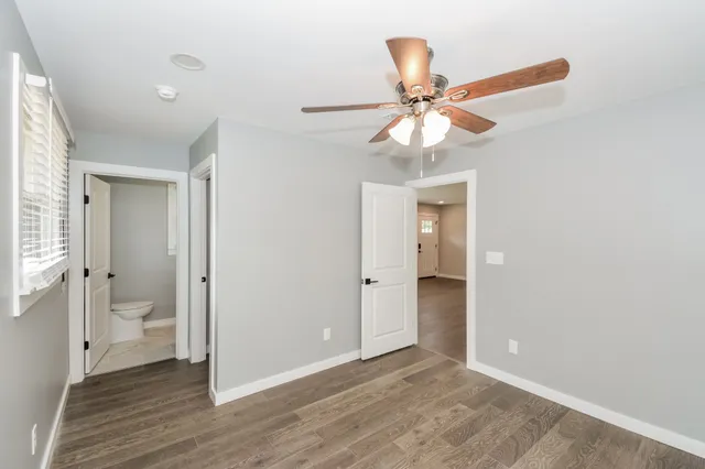 a view of a livingroom with a chandelier fan and a bathroom