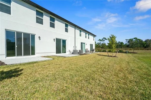 a view of a house with backyard and sitting area