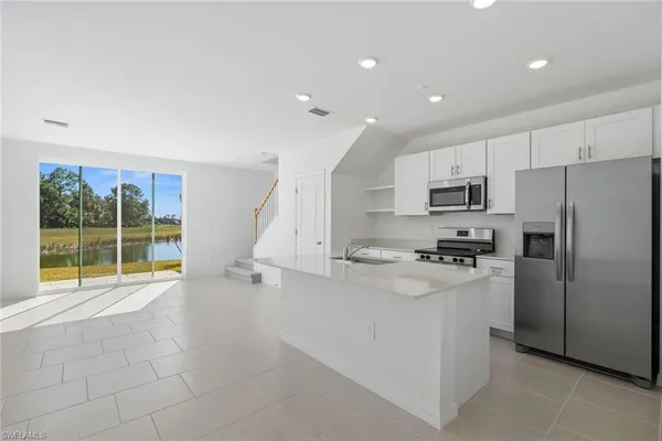 a kitchen with stainless steel appliances a refrigerator sink and stove