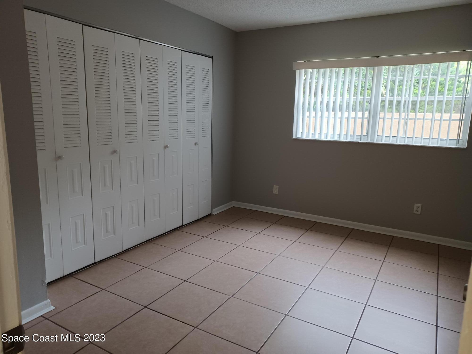 1698 Sunny Brook Lane, Unit G110 Palm Bay, FL 32905 - Photo 14 of 18 a view of an empty room with a window
