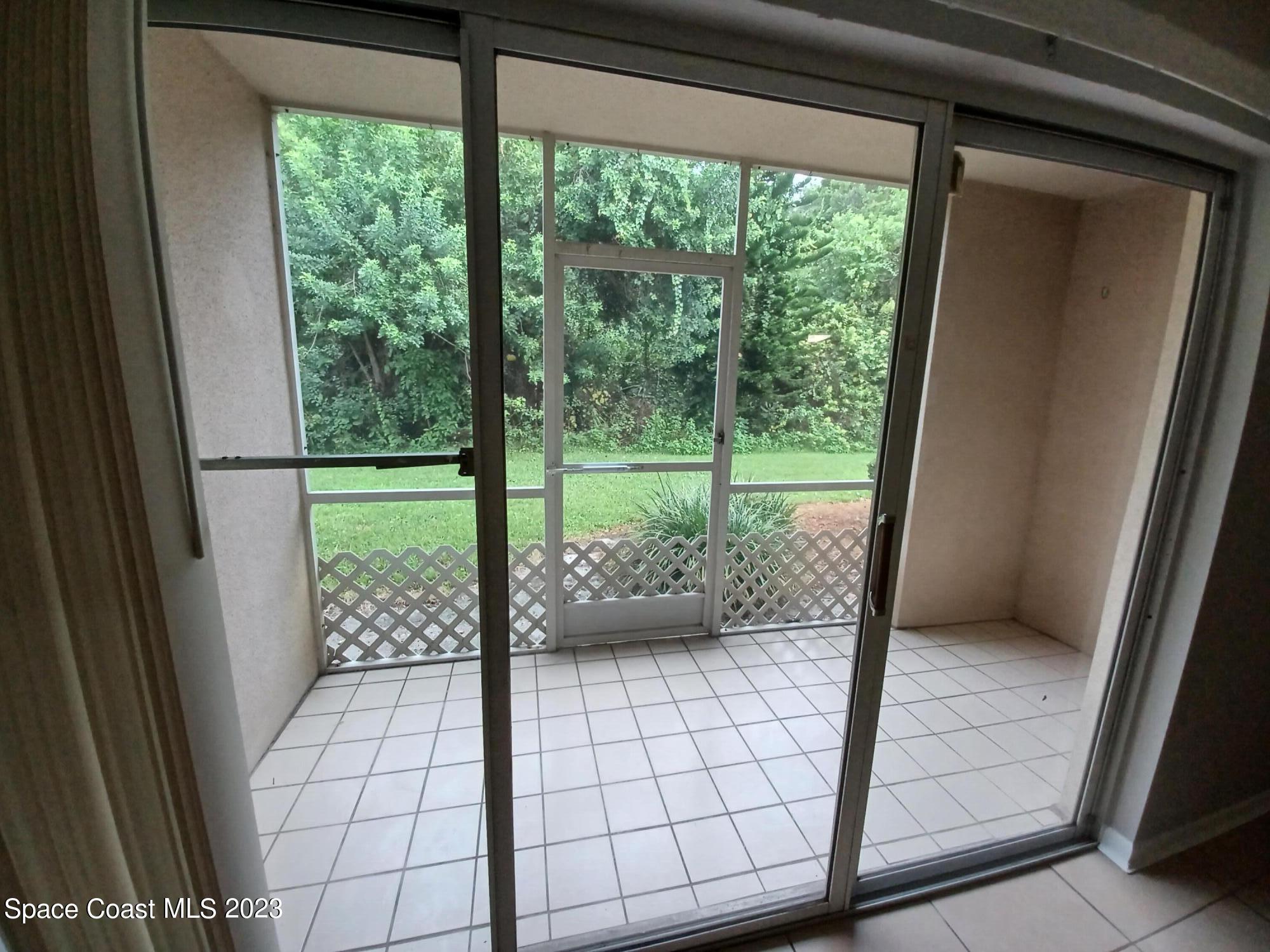 1698 Sunny Brook Lane, Unit G110 Palm Bay, FL 32905 - Photo 3 of 18 a bathroom with a glass door shower and yard