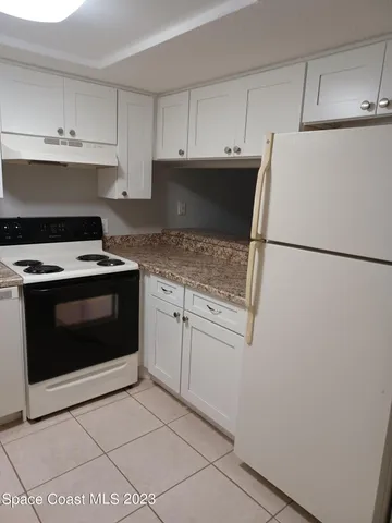 a kitchen with cabinets and white appliances