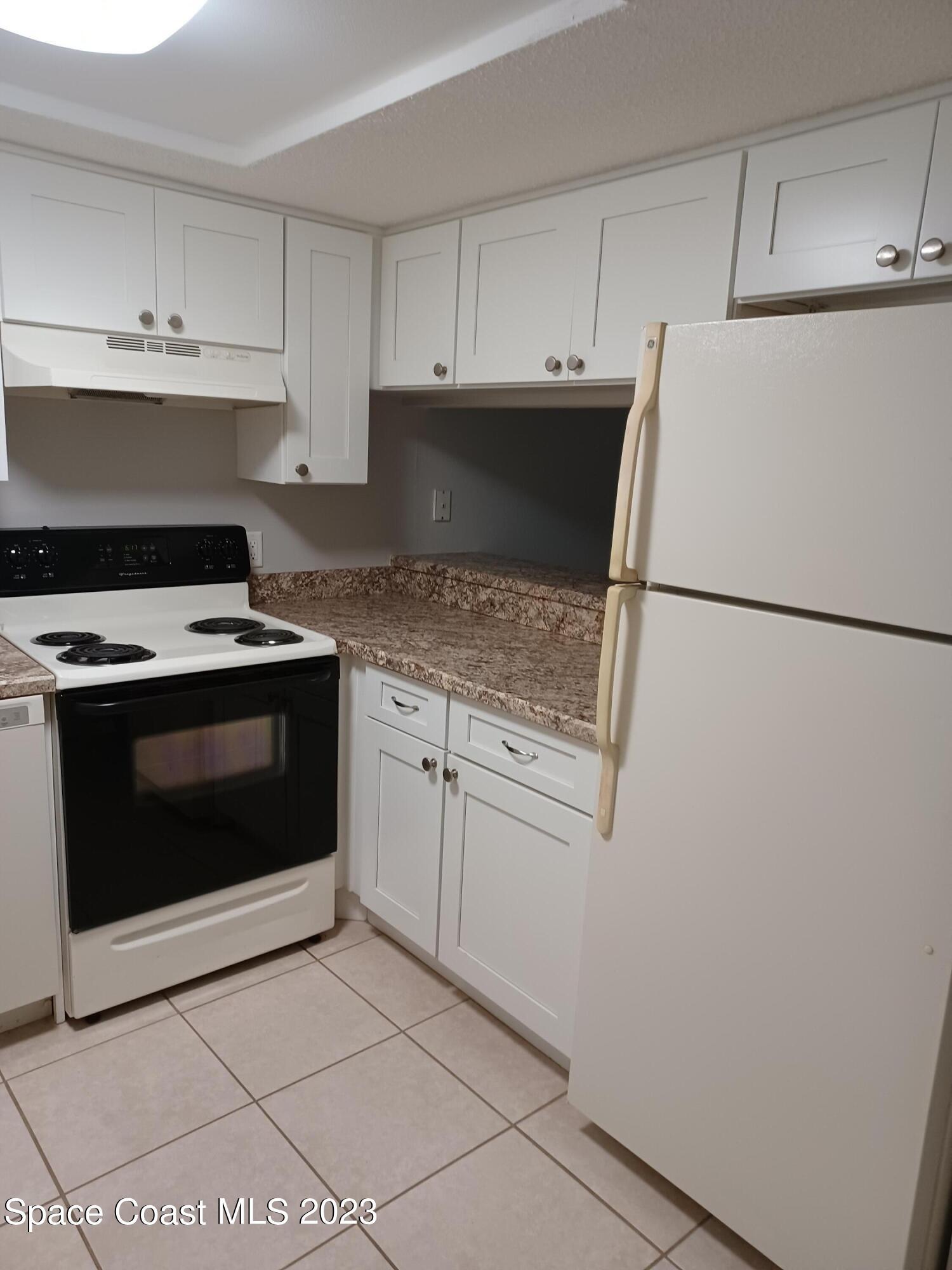 1698 Sunny Brook Lane, Unit G110 Palm Bay, FL 32905 - Photo 7 of 18 a kitchen with cabinets and white appliances