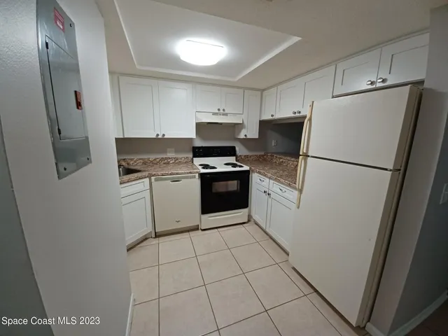 a white refrigerator freezer and a stove sitting inside of a kitchen