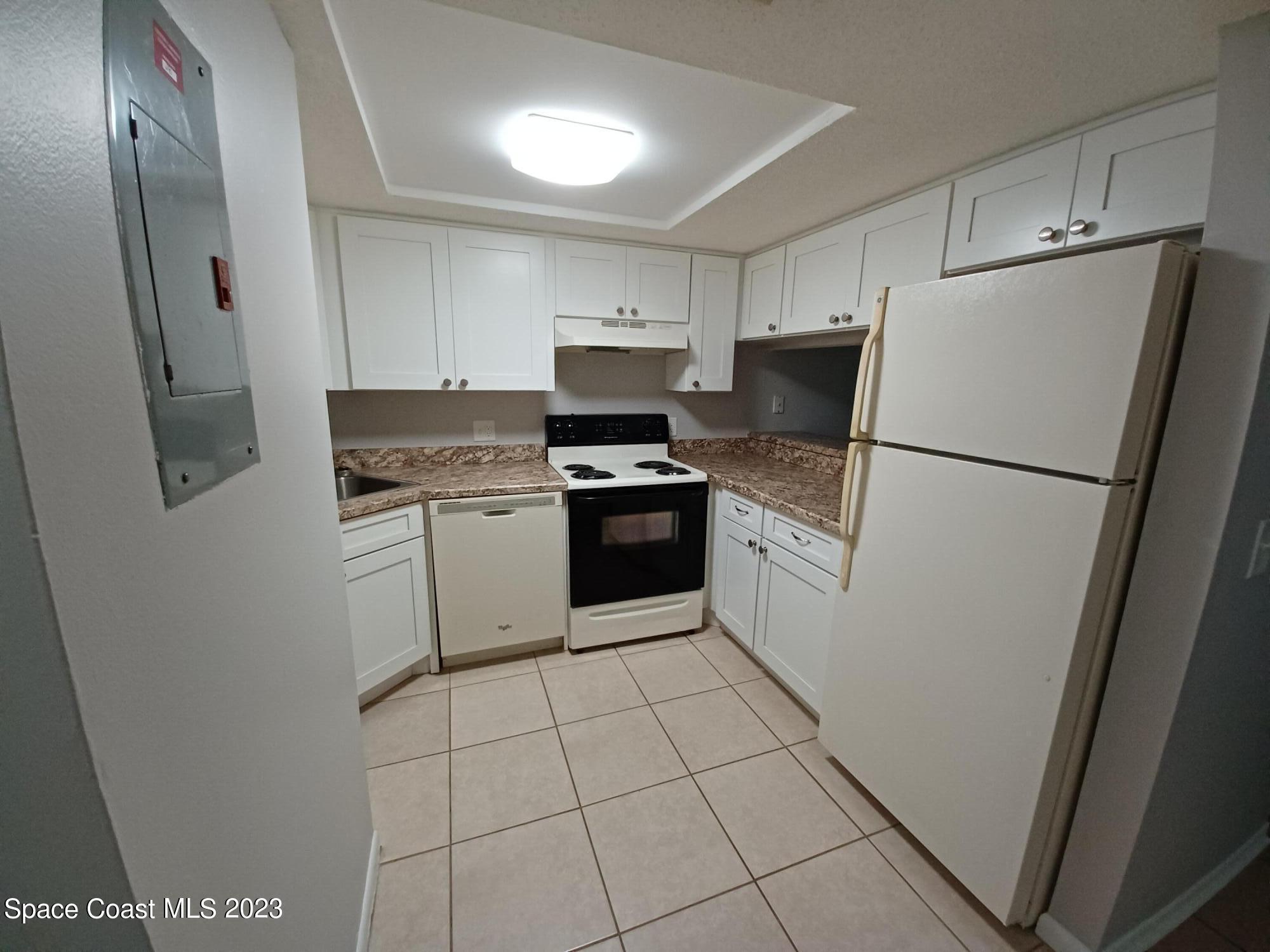 1698 Sunny Brook Lane, Unit G110 Palm Bay, FL 32905 - Photo 8 of 18 a white refrigerator freezer and a stove sitting inside of a kitchen