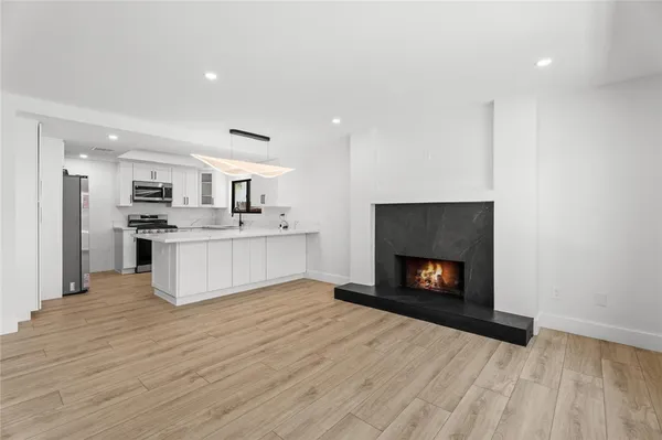 a view of kitchen with granite countertop stove top oven and refrigerator