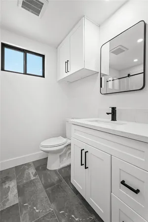 a bathroom with a toilet a sink and mirror