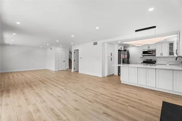 a view of a kitchen with a sink and a refrigerator
