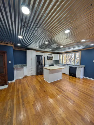 a view of kitchen with furniture and refrigerator