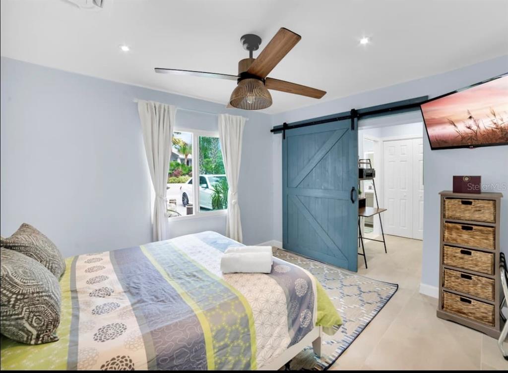 1210 Bay Palm Boulevard Indian Rocks Beach, FL 33785 - Photo 16 of 19 a bedroom with a bed and a chandelier