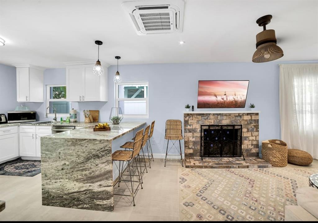 1210 Bay Palm Boulevard Indian Rocks Beach, FL 33785 - Photo 17 of 19 a kitchen with granite countertop a stove top oven a sink a dining table and chairs